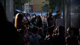 Padres y alumnos esperan a las puertas de un colegio en Cataluña.