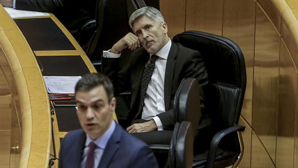 El ministro del Interior, Fernando Grande-Marlaska, atiende al presidente del Gobierno, Pedro Sánchez, en el Senado.