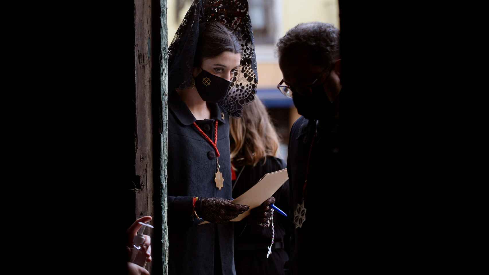 Una mujer vestida de manola controla los accesos a la catedral de Valladolid, donde se ha realizado la lectura del Sermón de las Siete Palabras.