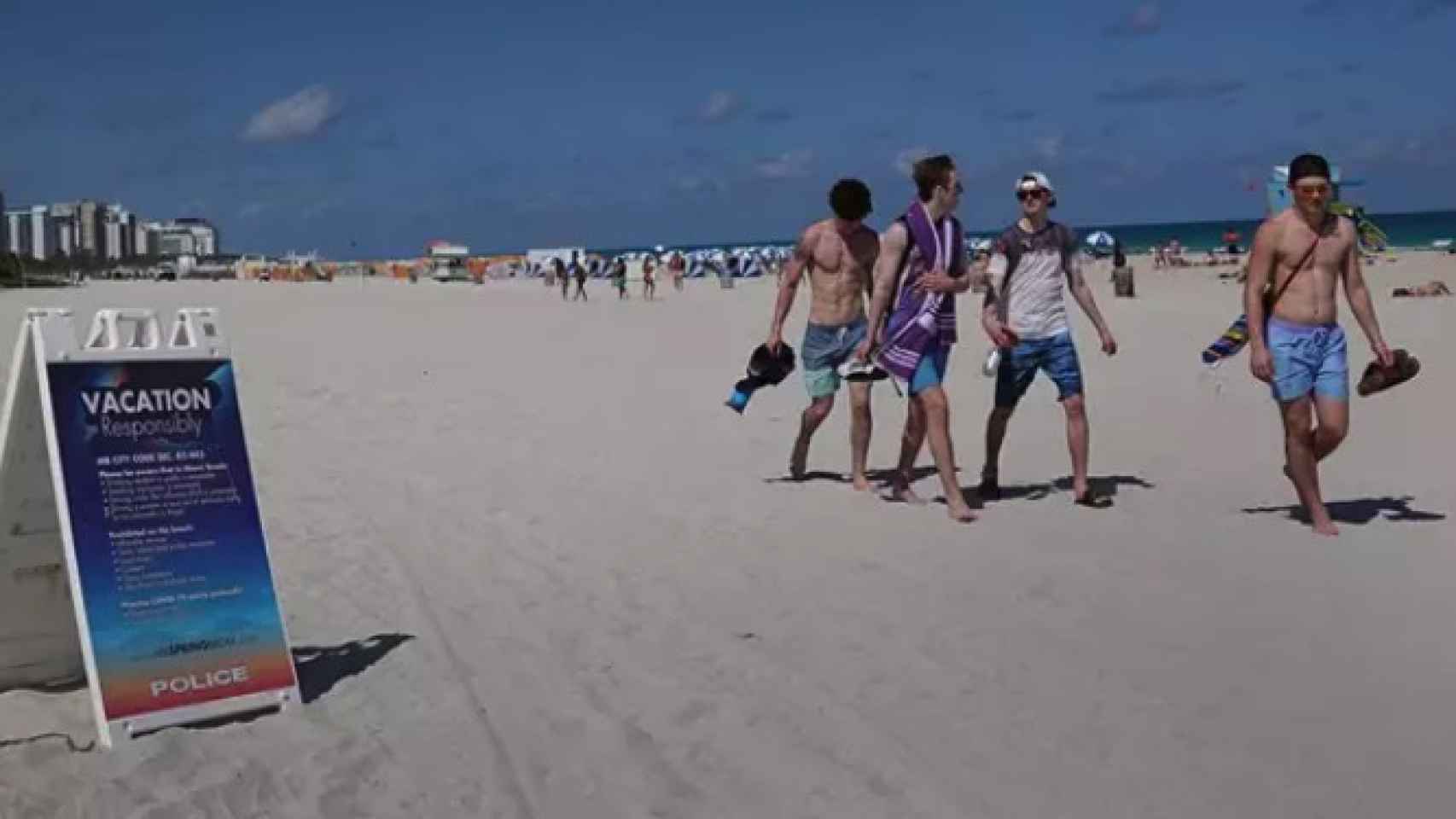 Varias personas caminan por la playa en Miami.