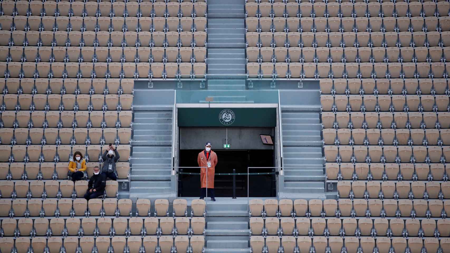 Tres espectadores en la grada de Roland Garros durante las restricciones de aficionados