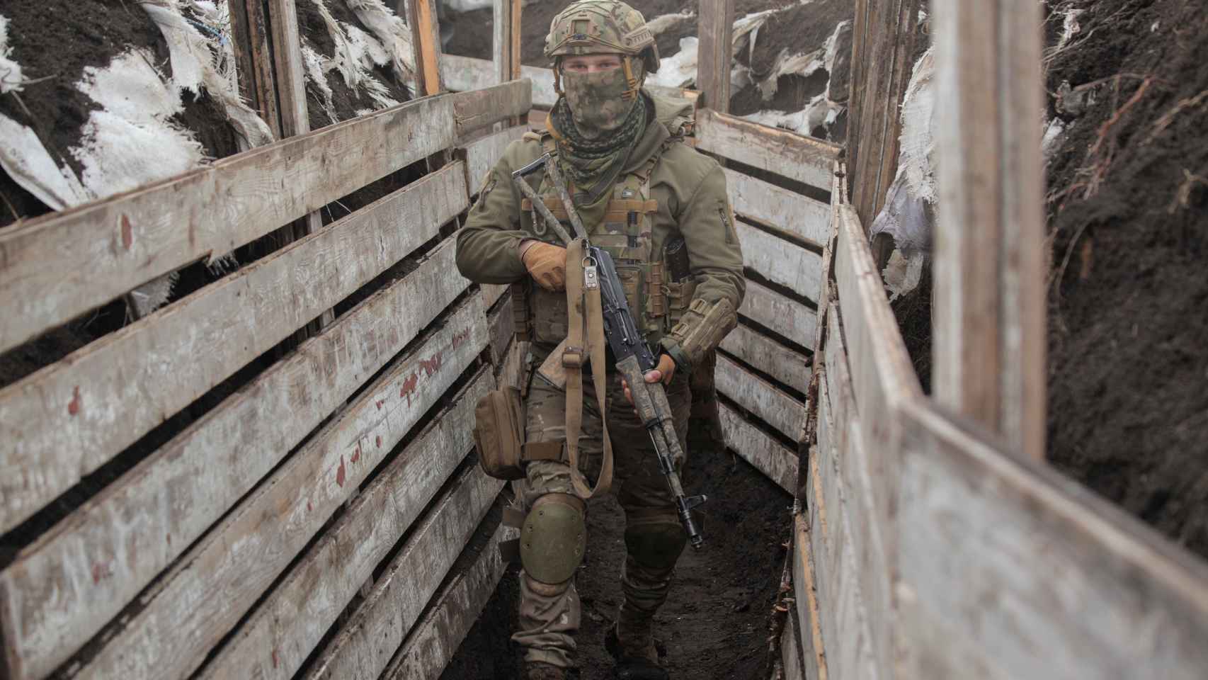 Un miembro de las fuerzas armadas ucranianas camina entre trincheras.