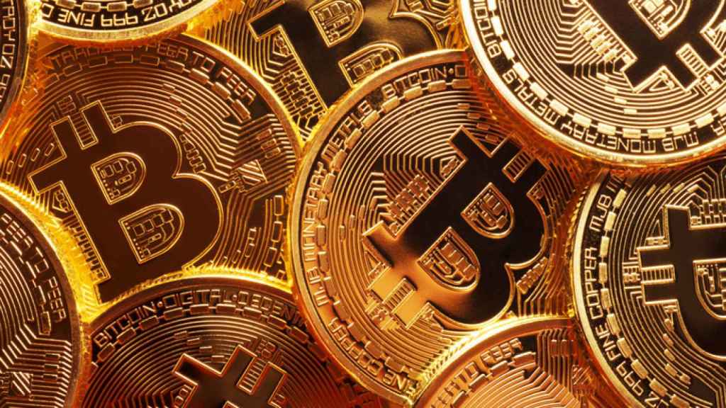 Varias monedas físicas de bitcoin en un montaje digital.
