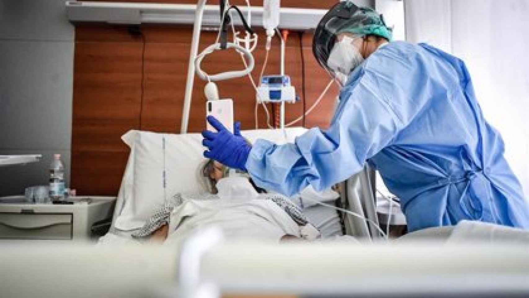 Un médico sujeta un móviles mientras un paciente habla con un familiar en un hospital de Italia. EP