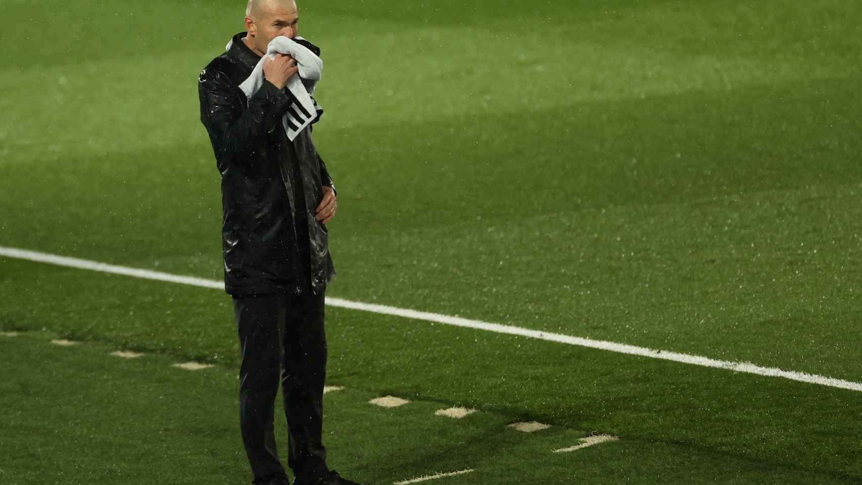 Zinedine Zidane se seca el agua de la lluvia que cayó durante El Clásico