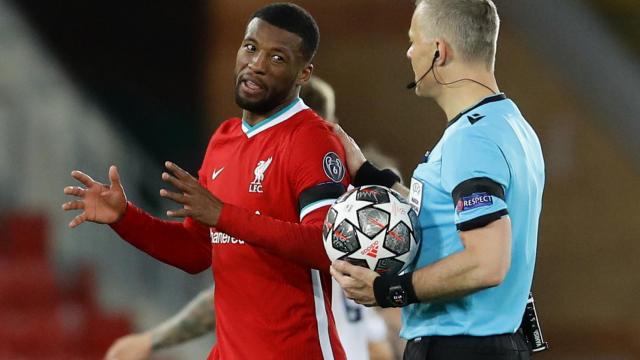 Georginio Wijnaldum habla con Bjorn Kuipers camino del vestuario en el descanso