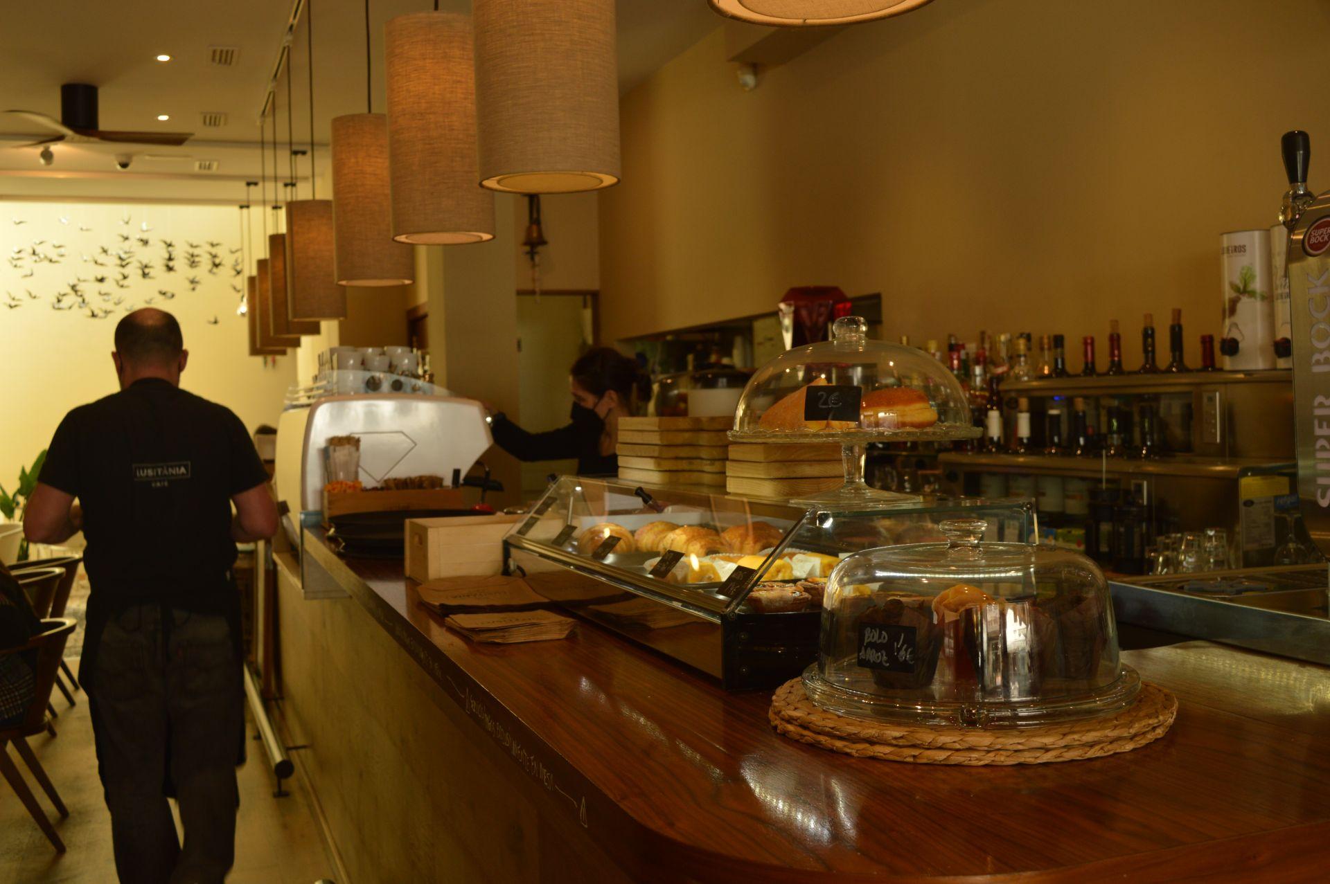 Antón atiende las mesas y Sofía prepara los cafés en el interior del Lusiânia Café, en Ferrol.