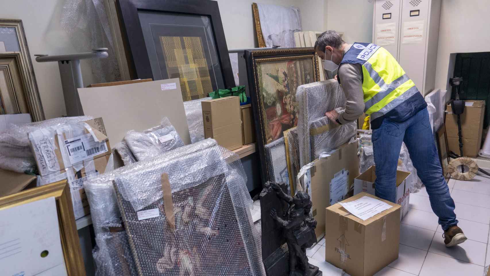 Antonio López manipula uno de los cuadros falsos que guarda en su almacén.