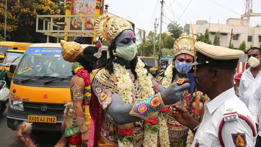 Figurantes caracterizados de dioses hindúes en una campaña por el uso de la mascarilla en Bangalore, India.