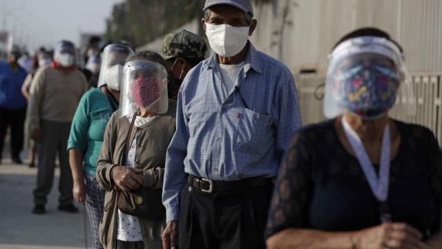 Varios peruanos esperan para acceder a un centro de votación en Lima.