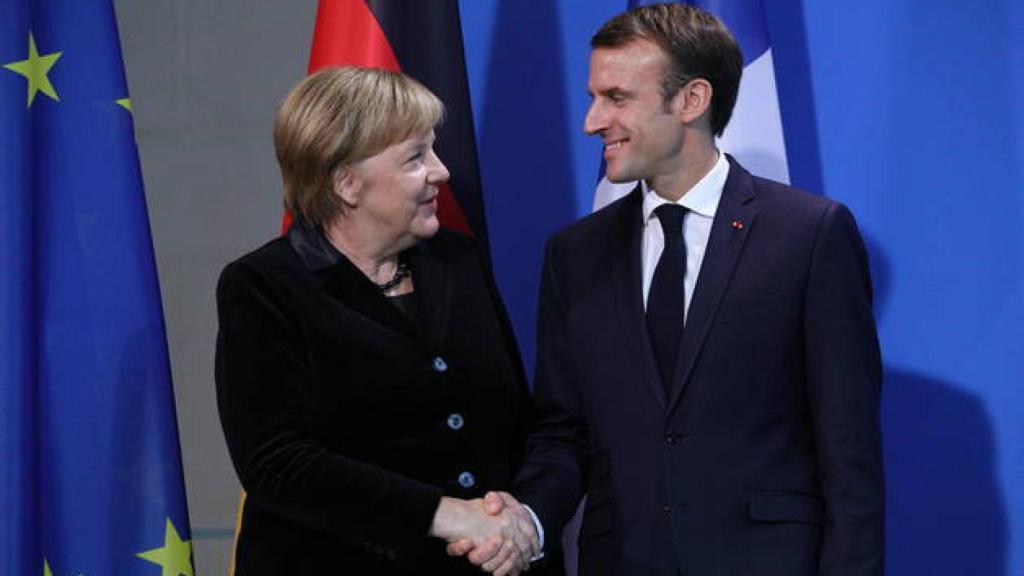 La canciller alemana, Angela Merkel, y el presidente francés, Emmanuel Macron, se dan la mano.