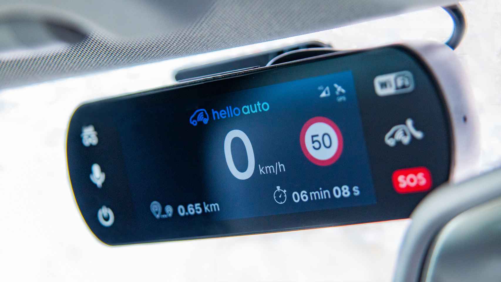 Imagen del dispositivo Hello Auto Connect colocado en el retrovisor de un vehículo.