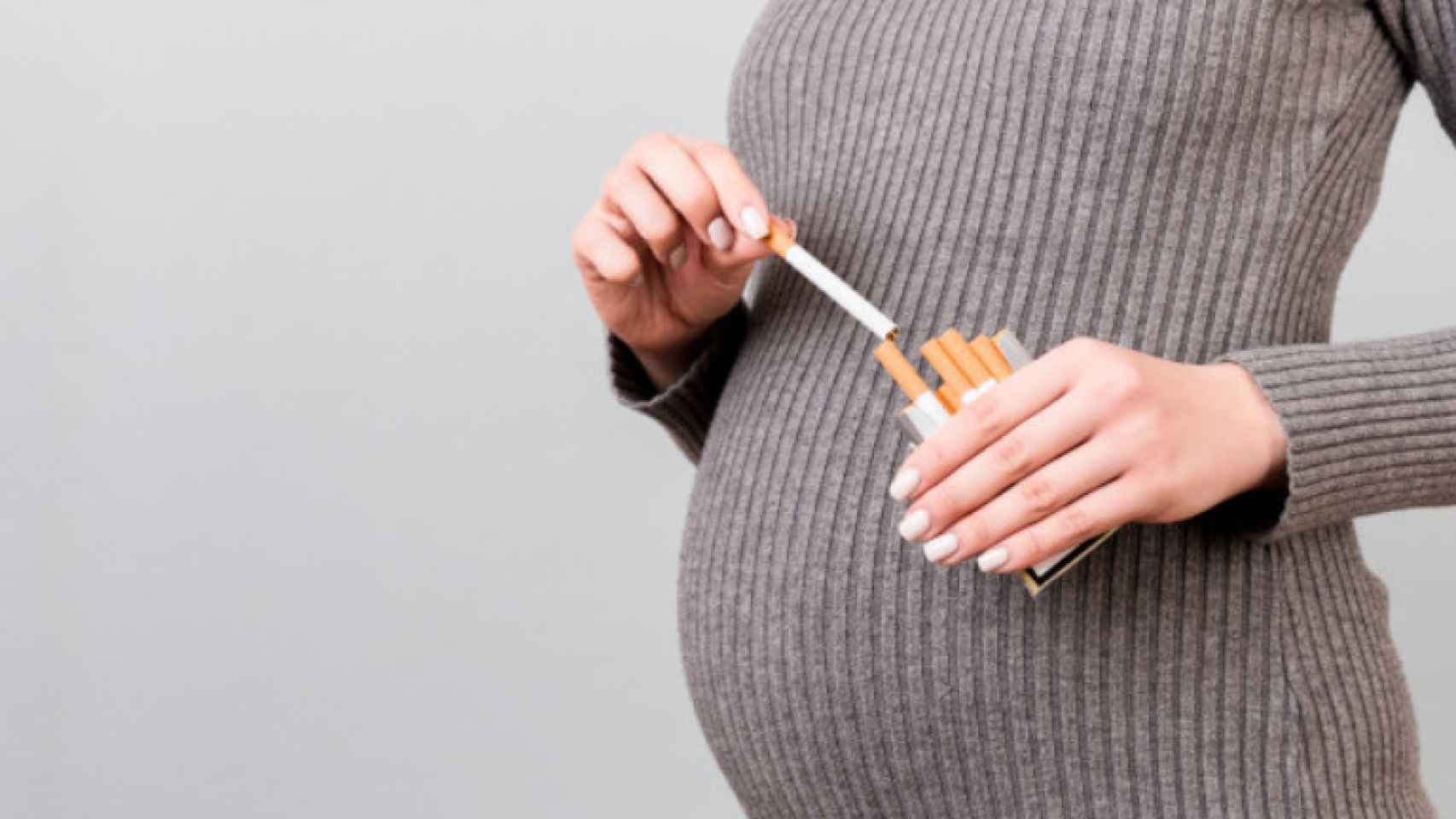 Una mujer embarazada con varios cigarrillos.