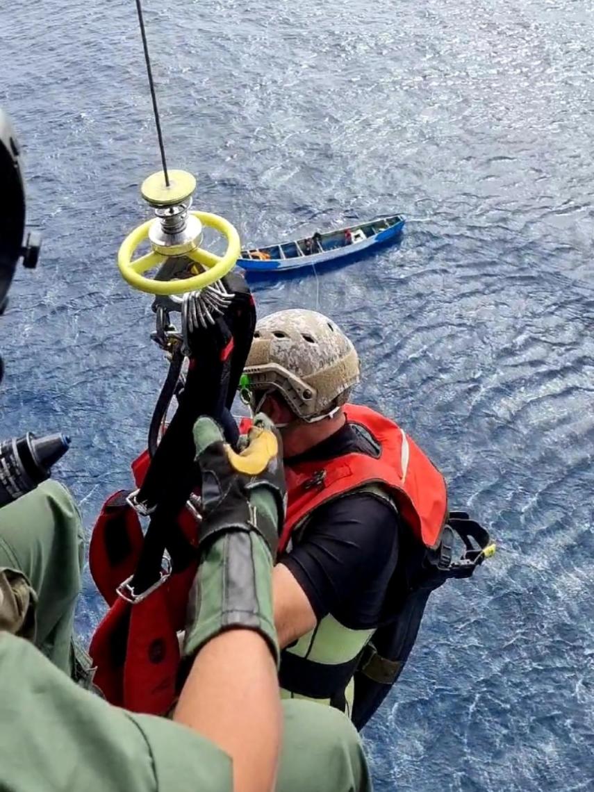 Uno de los soldados, descendiendo por el cable hacia la patera para consumar el rescate.