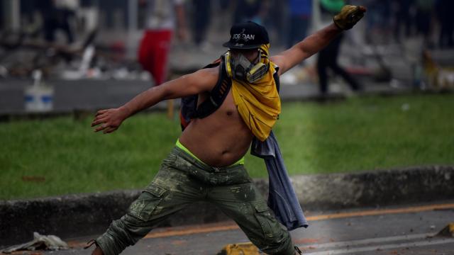 Manifestantes se enfrentan con miembros del Escuadrón Móvil Antidisturbios durante las protestas en Cali .