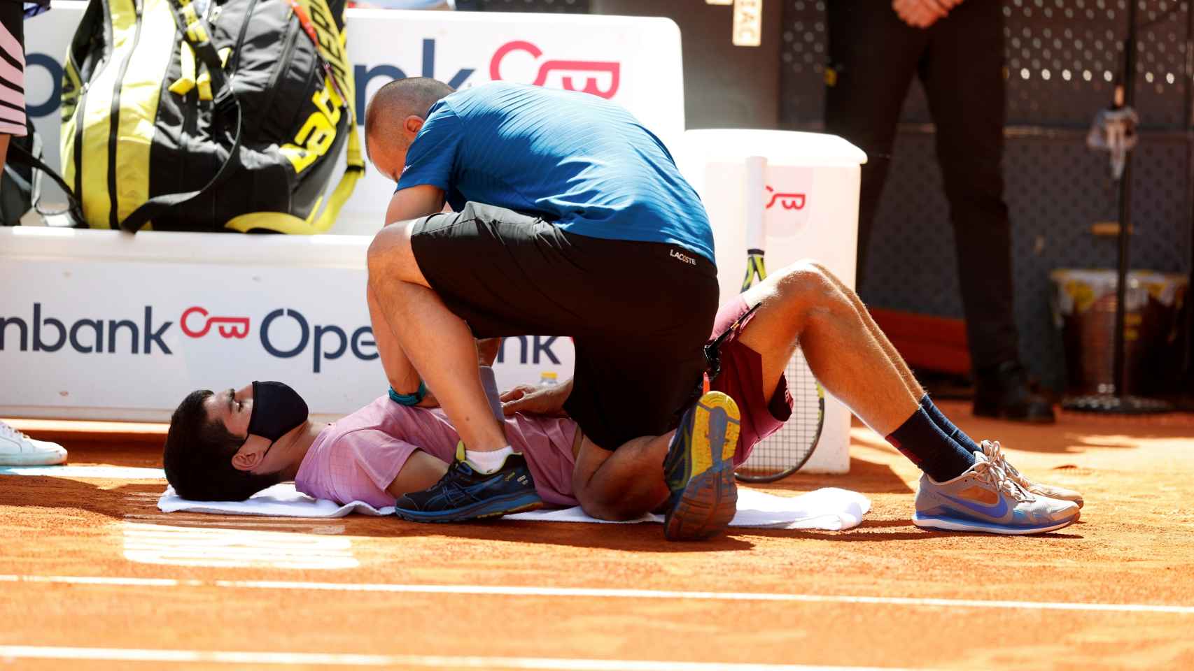 Carlos Alcaraz siendo atendido en el choque frente a Rafa Nadal en el Mutua Madrid Open