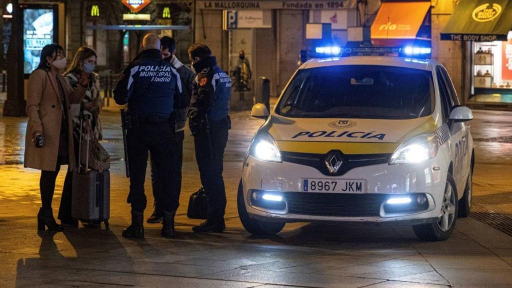 Dos policías municipales paran a viandantes en la Puerta del Sol de Madrid. Efe