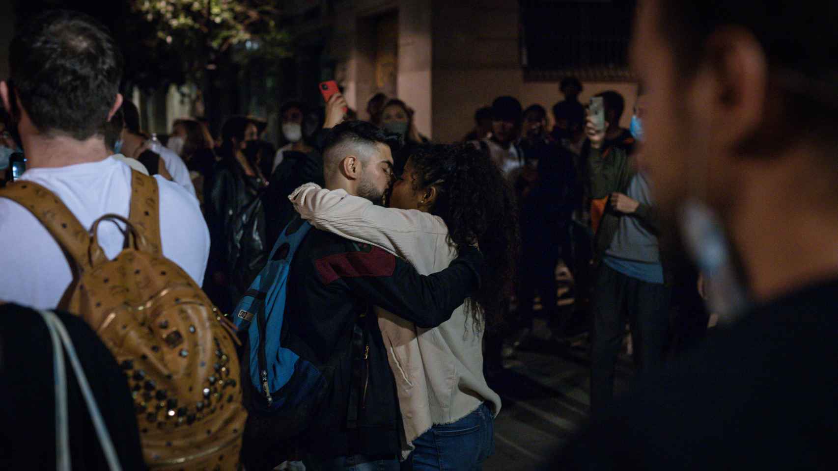Dos jóvenes besándose entre una multitud la pasada madrugada en Barcelona.
