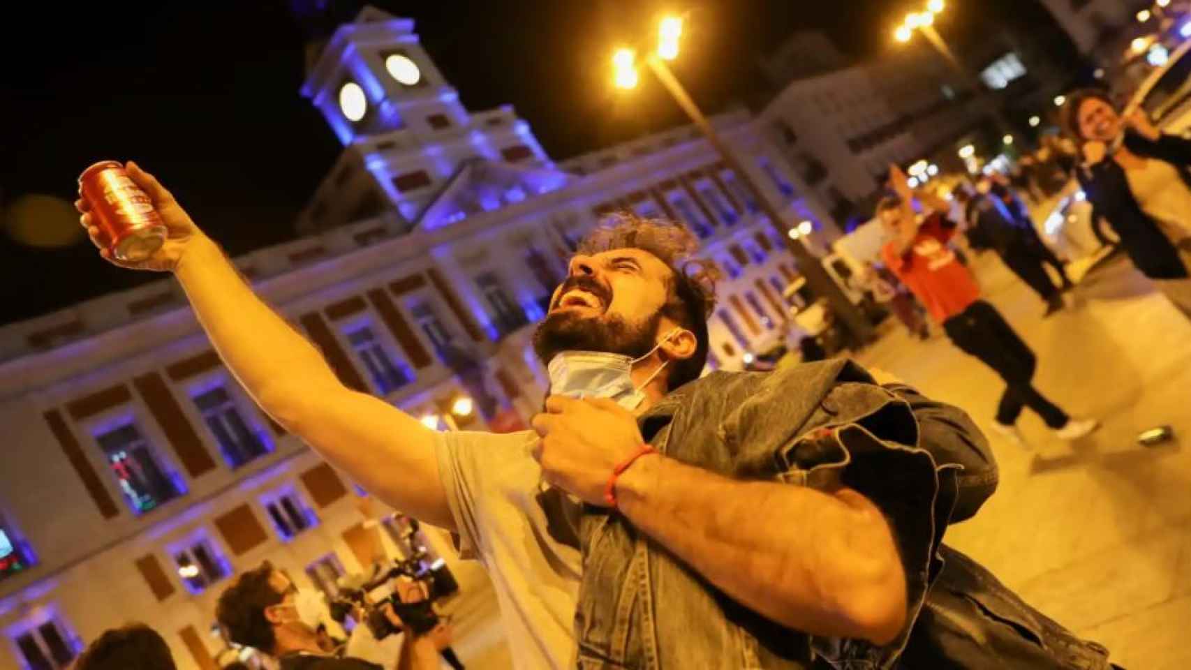 Un hombre brinda por el fin del estado de alarma en la Puerta del Sol de Madrid.
