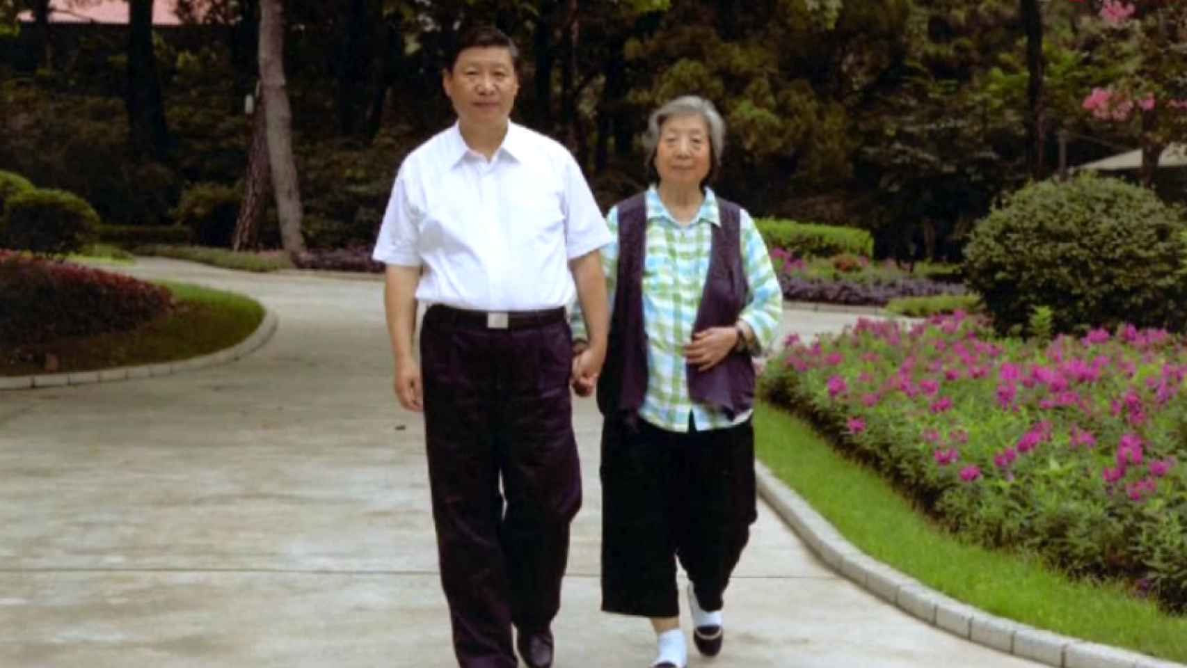 Xi Jinping camina junto a su madre, Qi Xing.