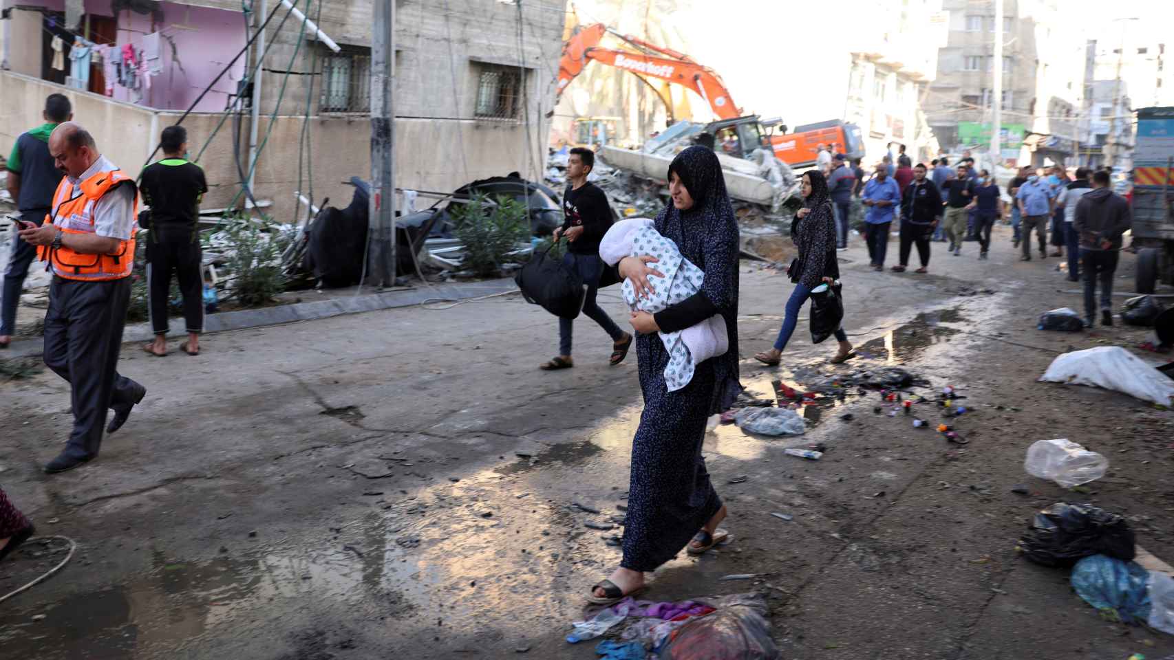 Una mujer lleva a su bebé durante los rescates en Gaza.