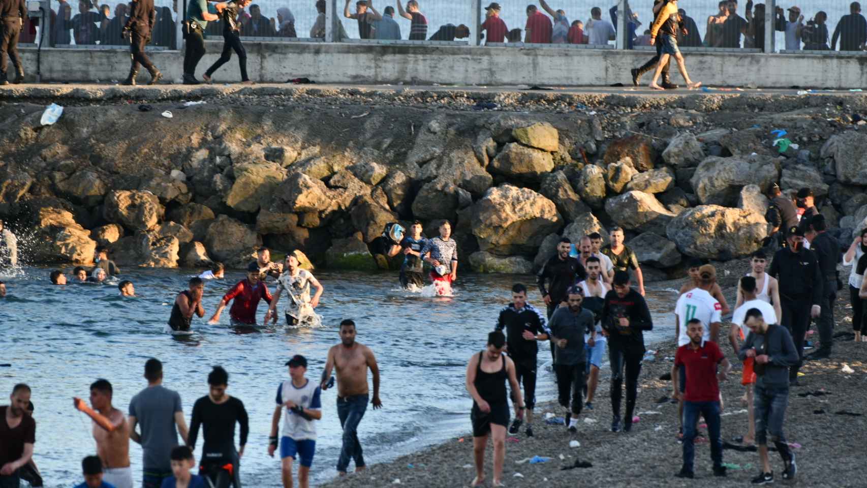 Los inmigrantes en el espigón de El Tarajal, en Ceuta.