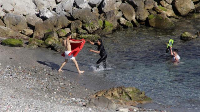 Un grupo de siete inmigrantes a su llegada esta mañana a Ceuta por el espigón sur del Tarajal.