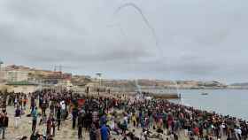 Cientos de personas esperan para cruzar los espigones de Ceuta en la frontera marroquí.