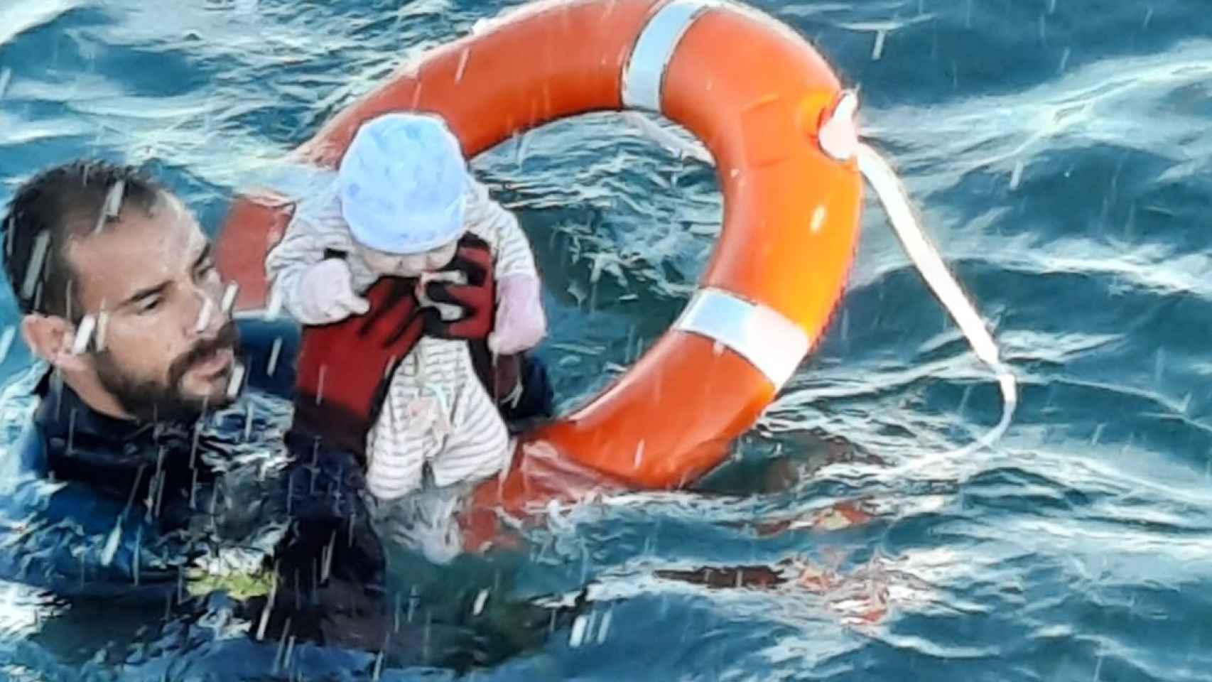 Un agente de la Guardia Civil sostiene a un bebé de pocos meses al que ha salvado en el agua de Ceuta.