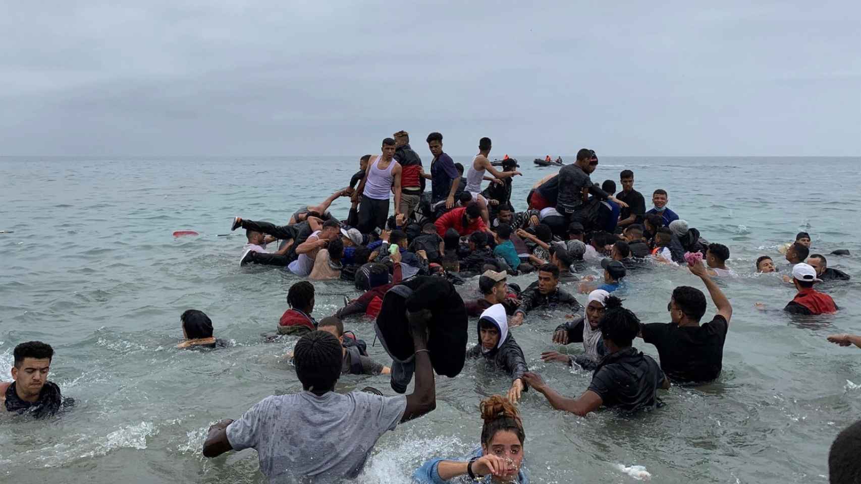 Menores inmigrantes entran a la playa de El Tarajal en Ceuta desde Marruecos.