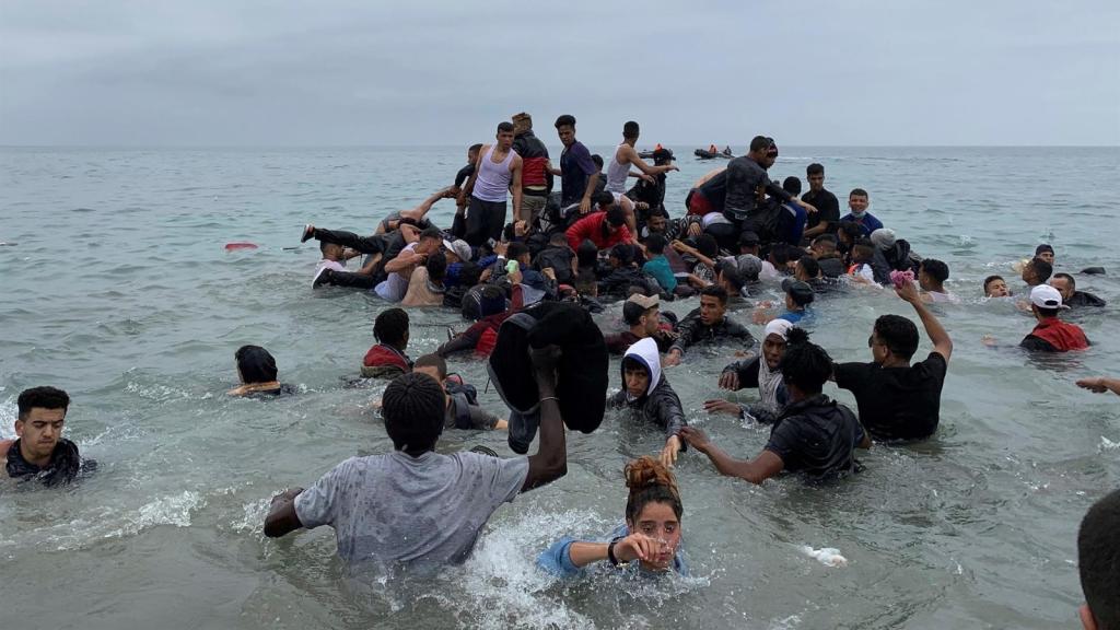 Menores inmigrantes entran a la playa de El Tarajal en Ceuta desde Marruecos.