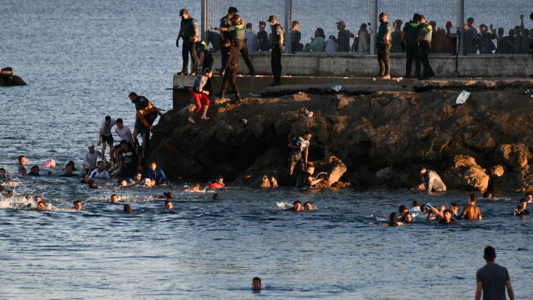 Decenas de personas bordean el espigón que separa territorio marroquí de Ceuta, la semana pasada.