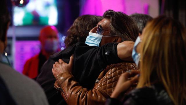 Dos personas se abrazan con mascarilla en Sitges (Barcelona).