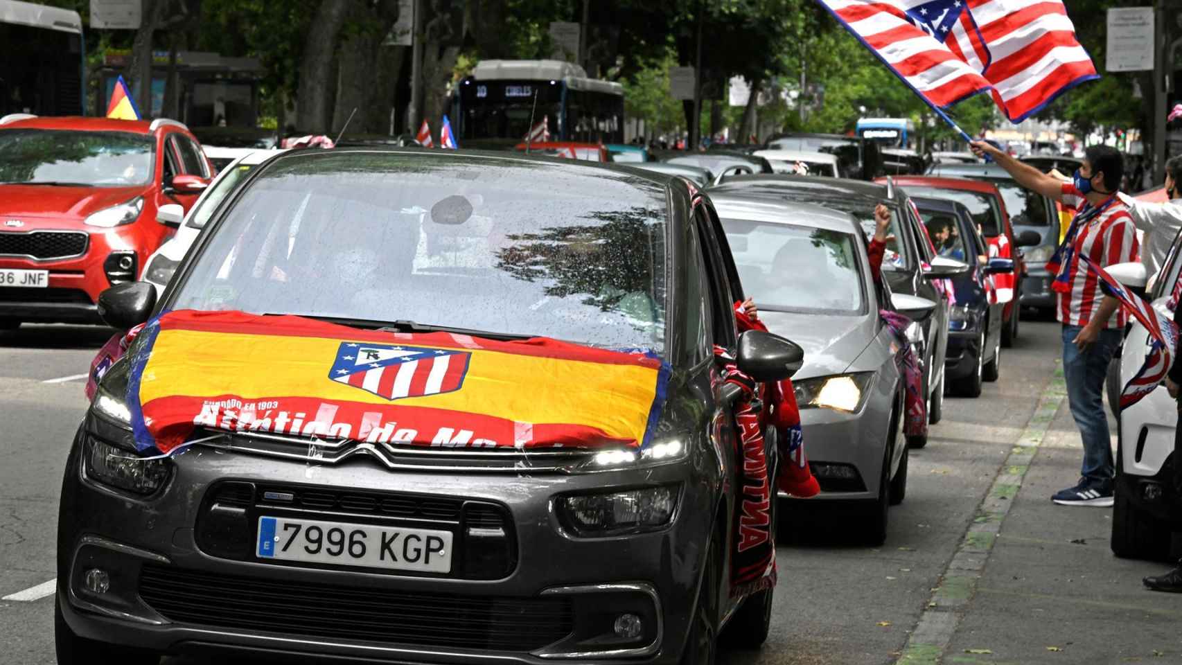 Un coche luce la bandera de España con el escudo del Atlético