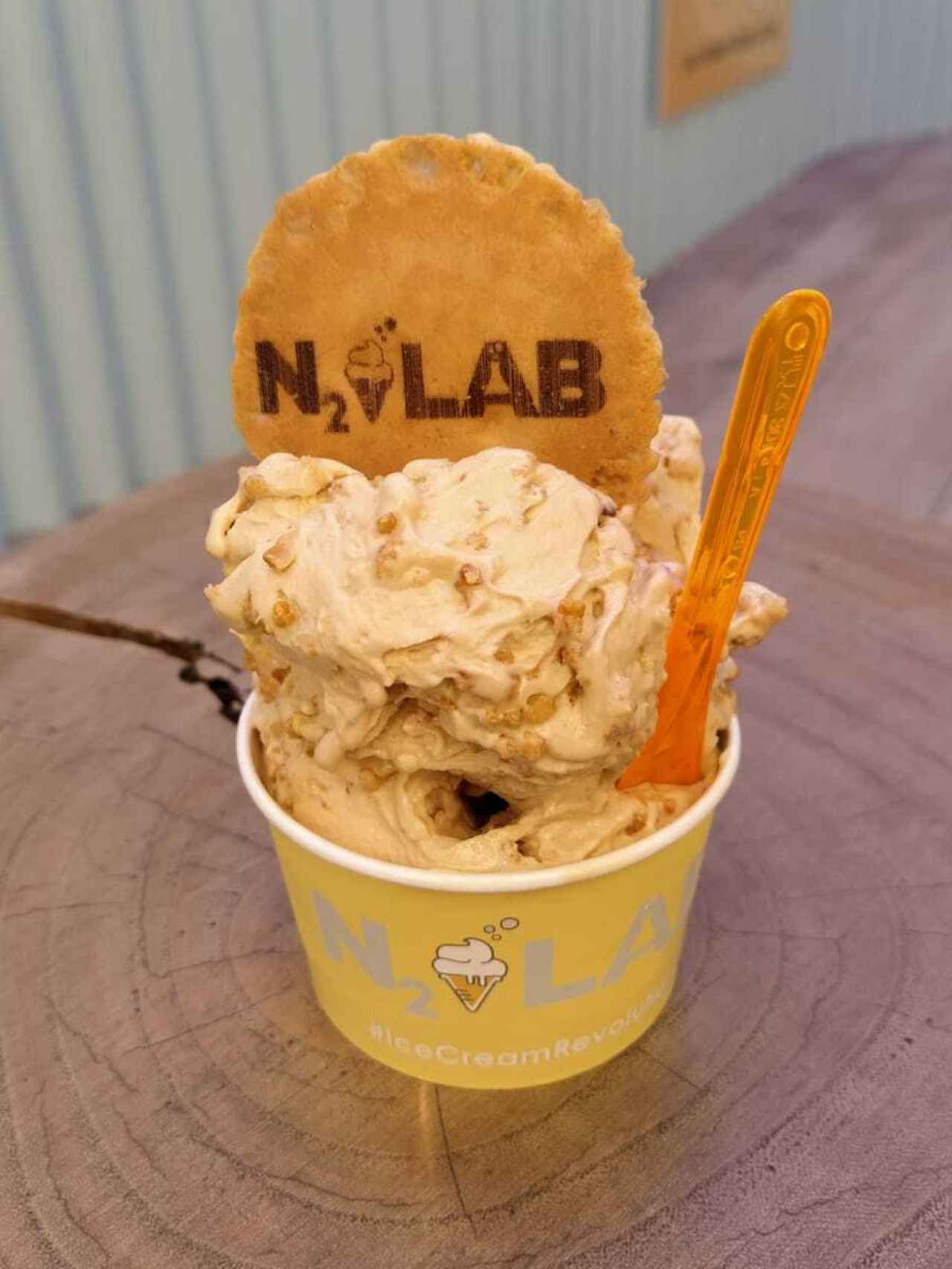 La tarrina de helado de N2 Lab, que contiene una bola de helado de caramelo con un 'topping'.