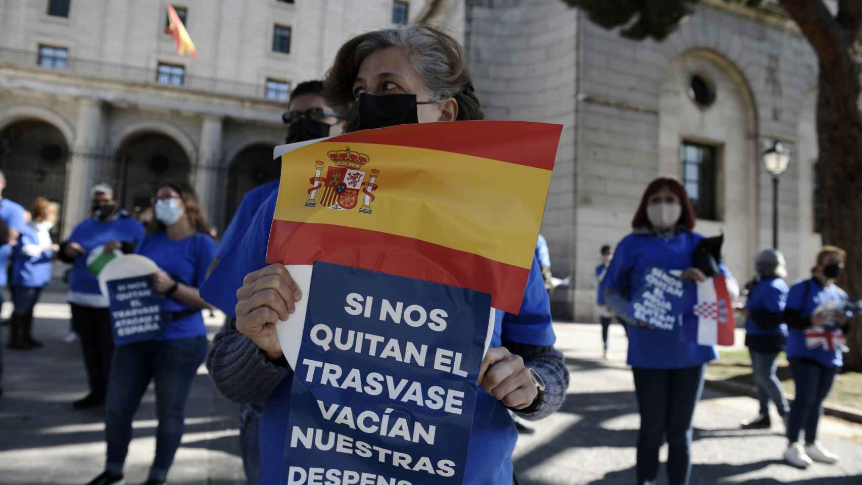 Una mujer con una pancarta y una bandera en la concentración contra el recorte de caudal del Trasvase Tajo-Segura .