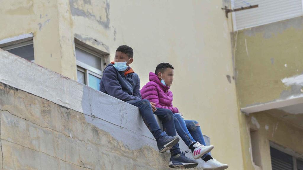 Dos menores encaramados a un muro en una de las naves de El Tarajal.