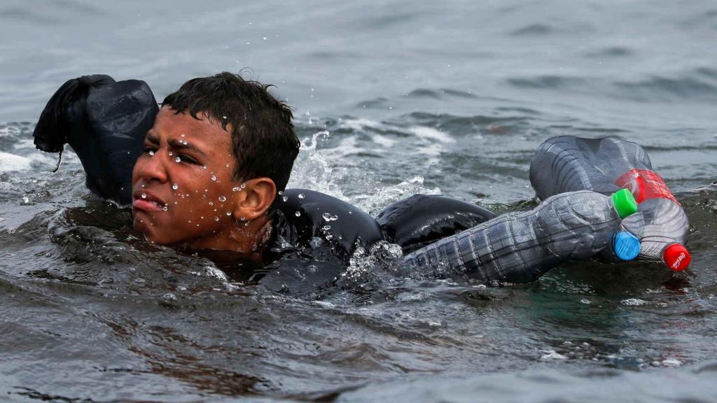 Un menor trata de llegar a nado a España por el espigón de El Tarajal.