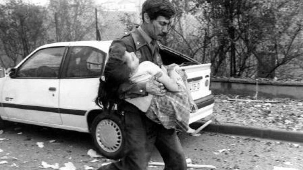 Uno de los agentes de la Guardia Civil rescata a una de las niñas de los escombros.