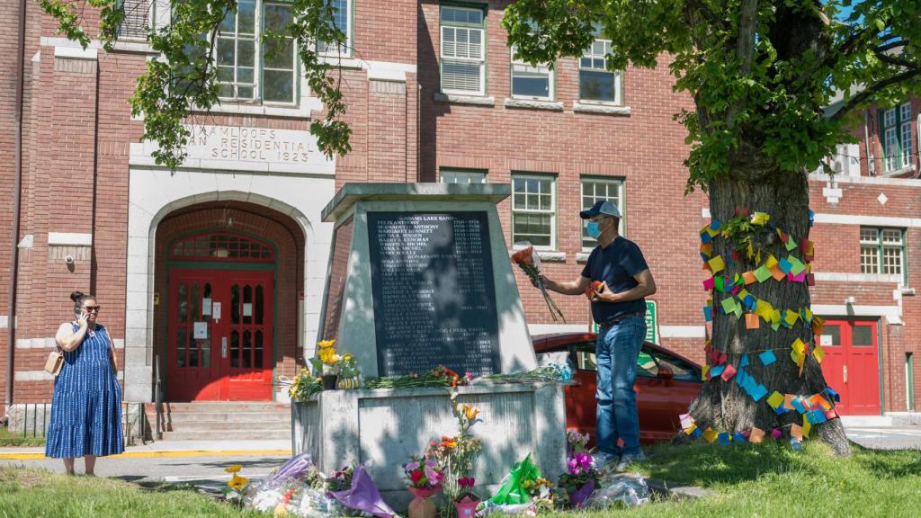 Varias personas ante las puertas de la antigua residencia escolar de Kamloops.