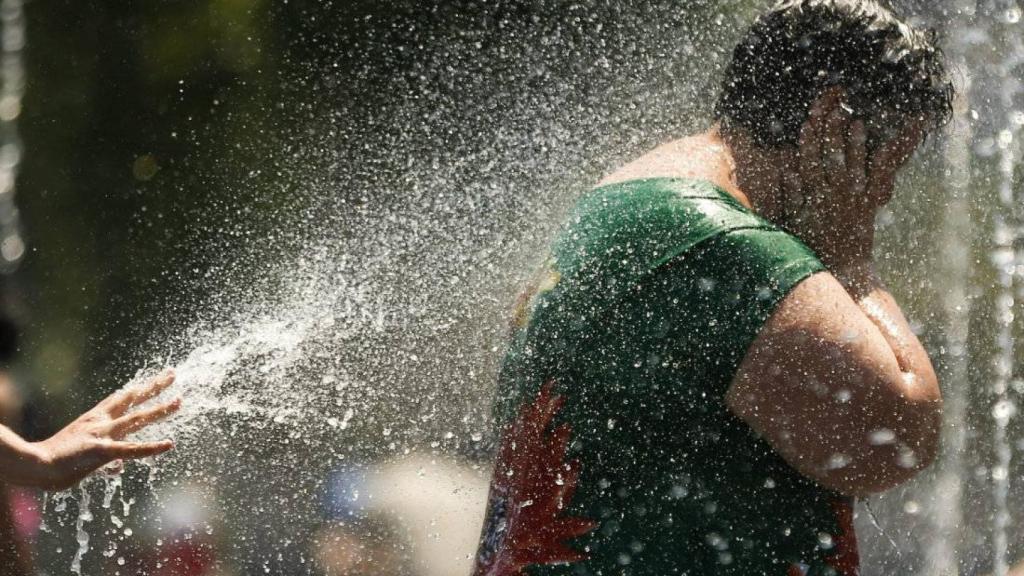 Una persona se refresca debido a las altas temperaturas.