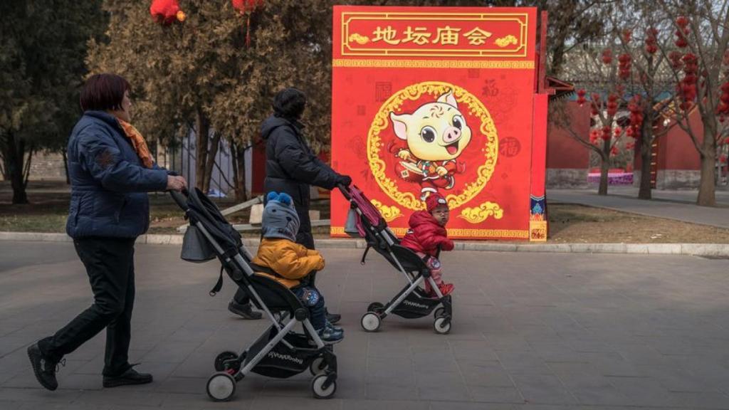 Parejas chinas paseando con sus hijos.