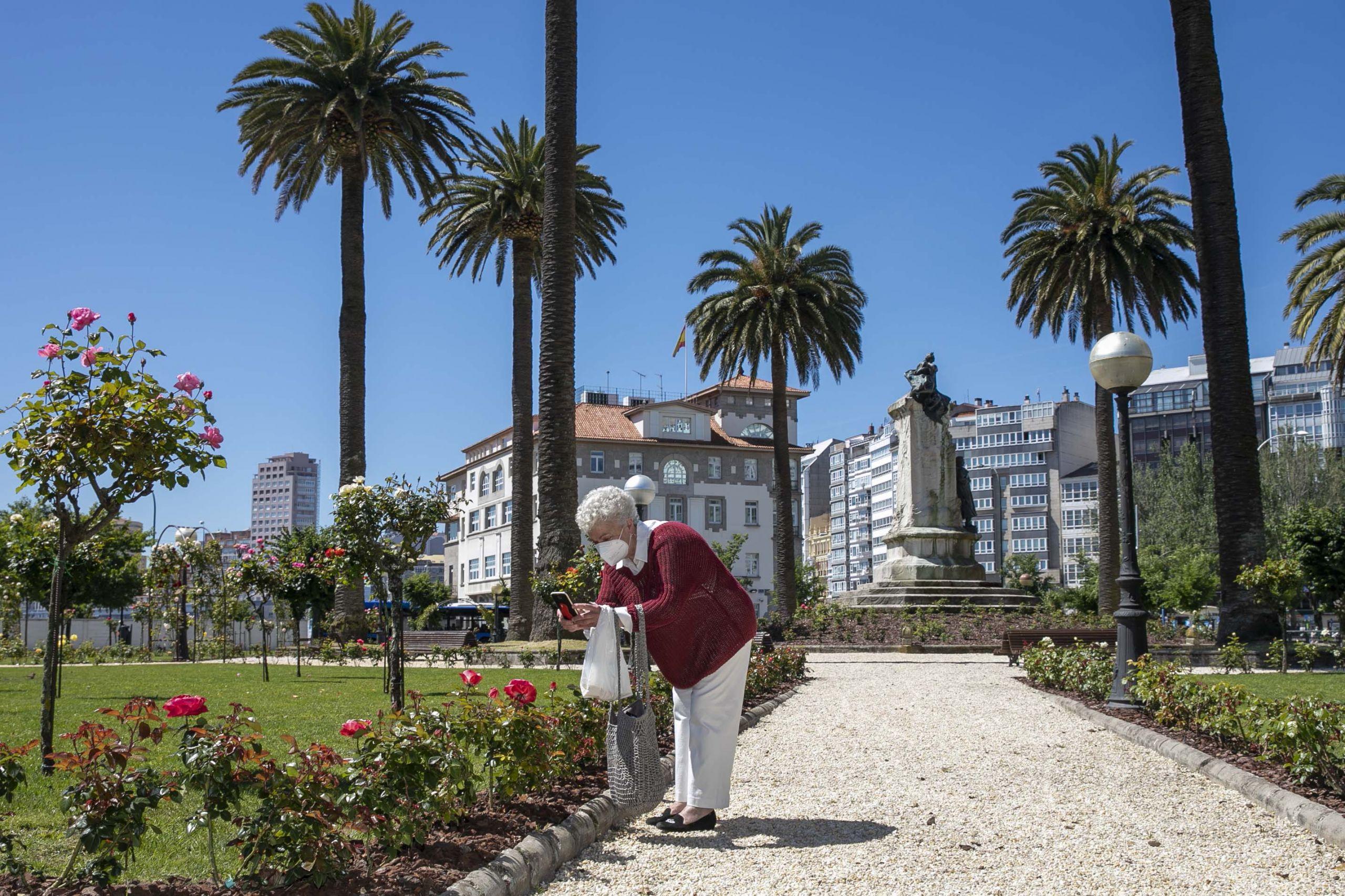 Una mujer saca una foto en la Rosaleda (Concello da Coruña).