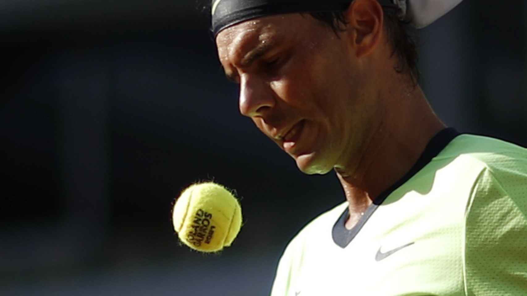 Rafa Nadal, escogiendo pelota antes de sacar en Roland Garros 2021