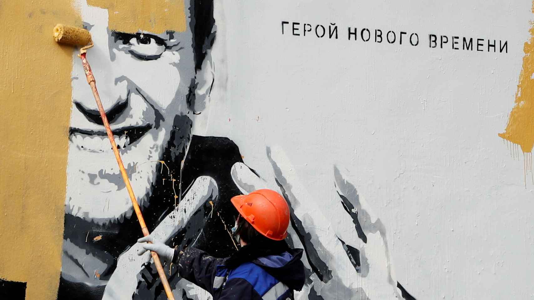 Un trabajador borra un mural de Navalny.