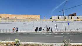 Varios migrantes procedentes de Marruecos hacen cola en las puertas de la frontera de Ceuta.