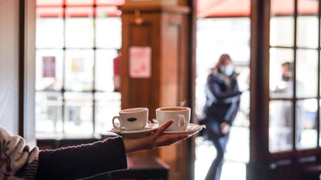 Un camarero sirve varios cafés en Vitoria.