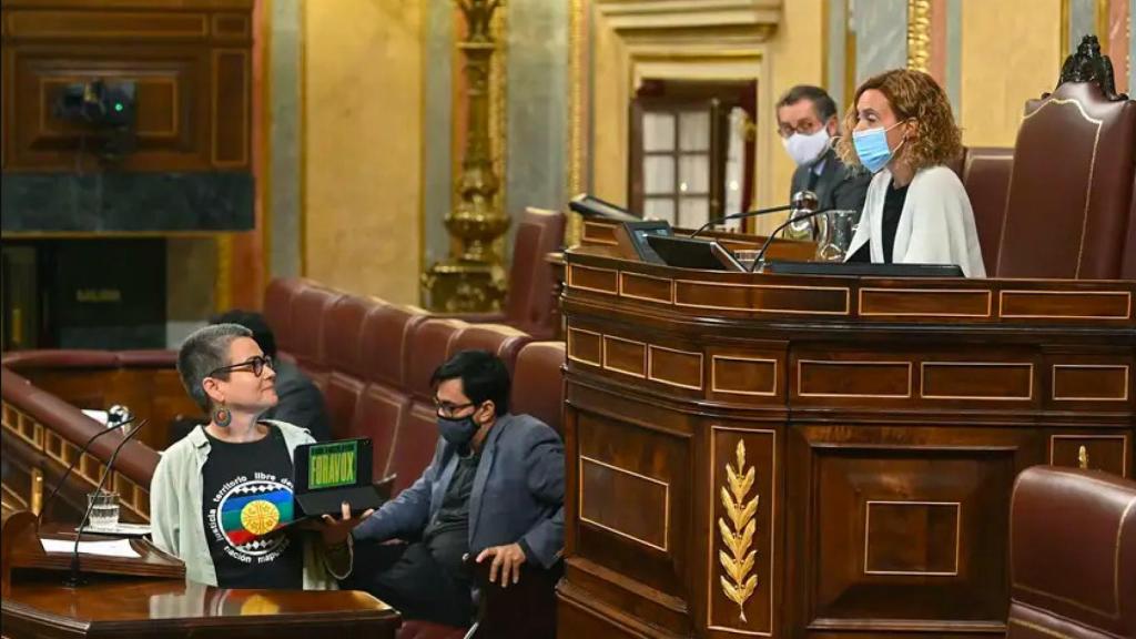 La diputada de ERC, María Cavalho escucha a Batet mientras ésta le reprende por la pancarta de Fora Vox que lleva en su Tablet.