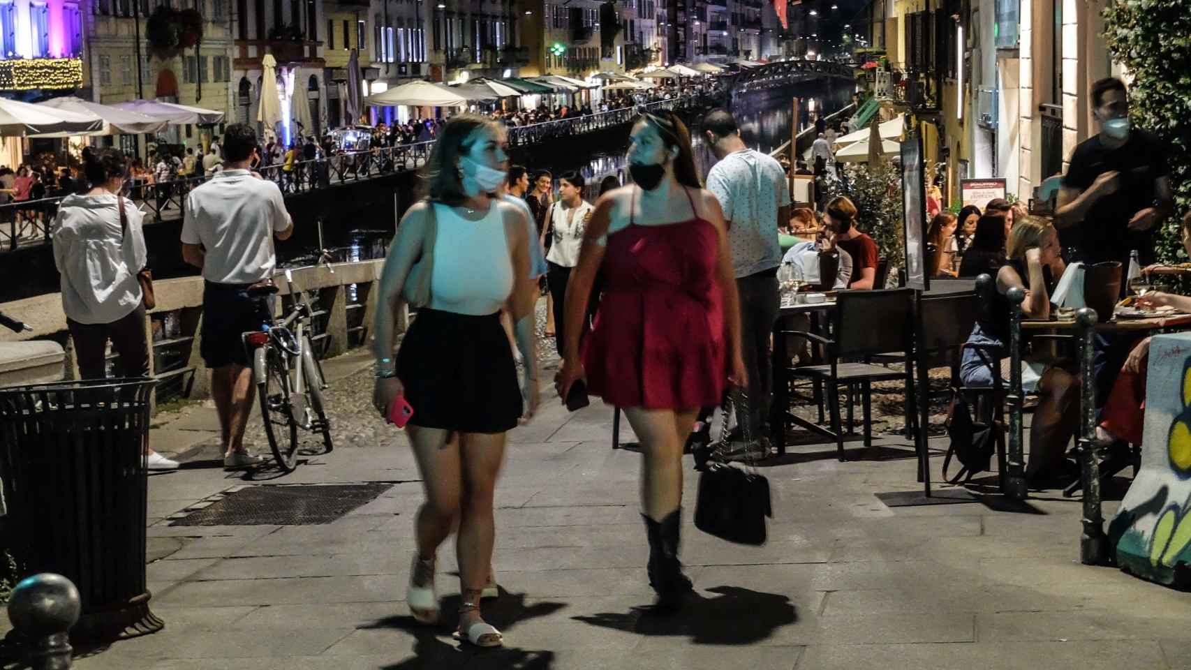 Jóvenes pasean por Milán en una concurrida zona de restaurantes.
