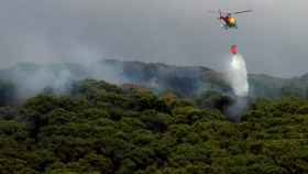 Un helicóptero sobrevolando la zona del incendio forestal en Argentona.